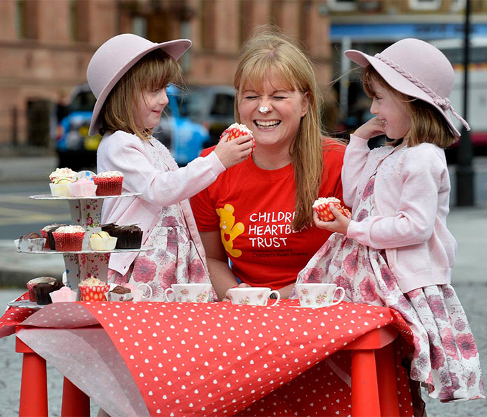 Woman with two children at a bake sale for CHT